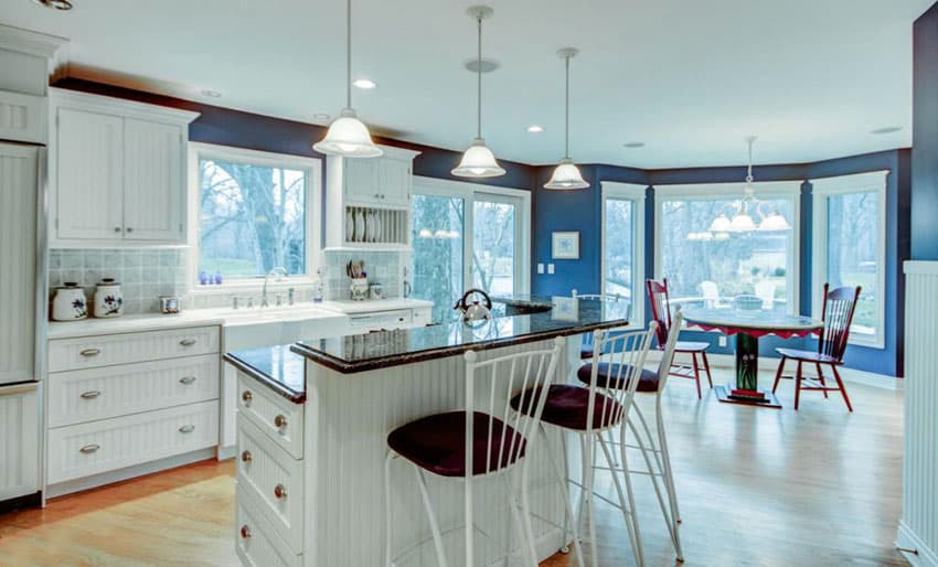 Blue painted kitchen with bi-level breakfast bar and red stools