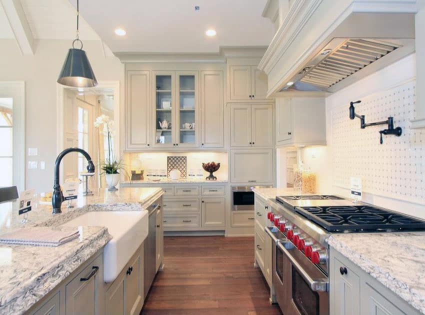 Country style galley kitchen with white cabinets, farmhouse sink and subzero wolf range