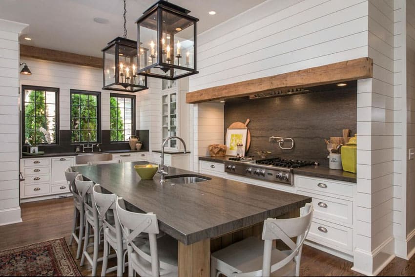 Kitchen with white european cabinets, travertine counter island and backsplash