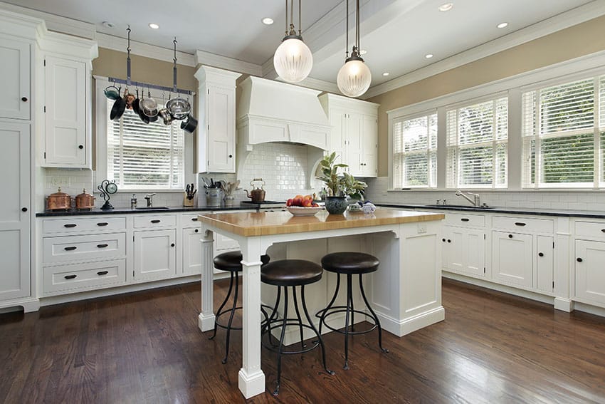 Country kitchen with shaker cabinets, butcher block island and black granite countertops