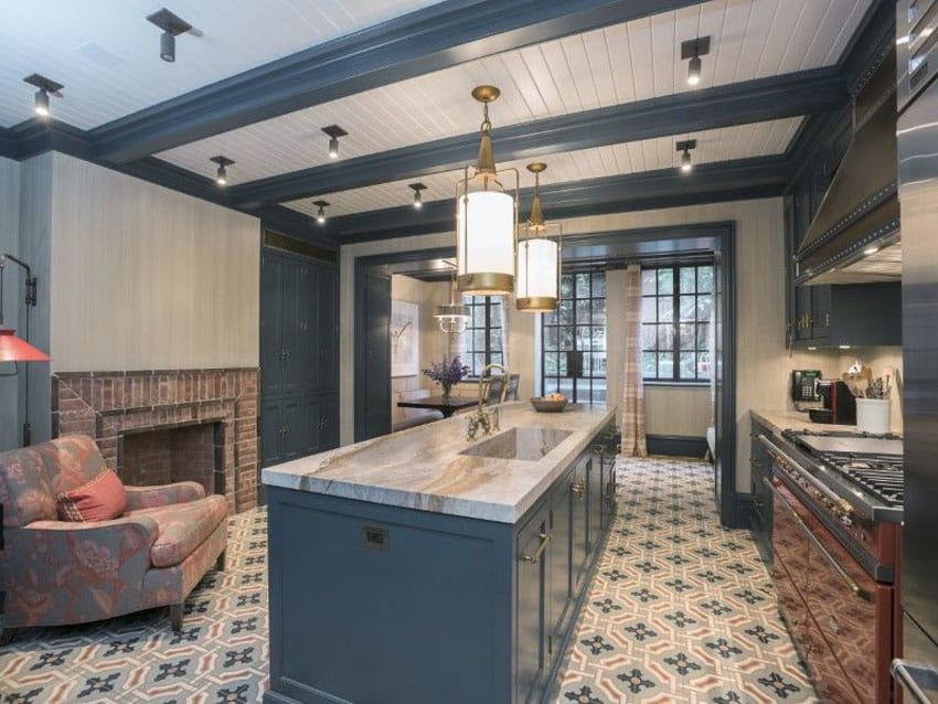 Elegant kitchen with dark blue cabinets, white marble counters and brick fireplace