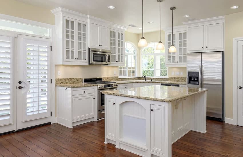 Kitchen with engineered oak hardwood flooring and white cabinets with yellow granite countertops