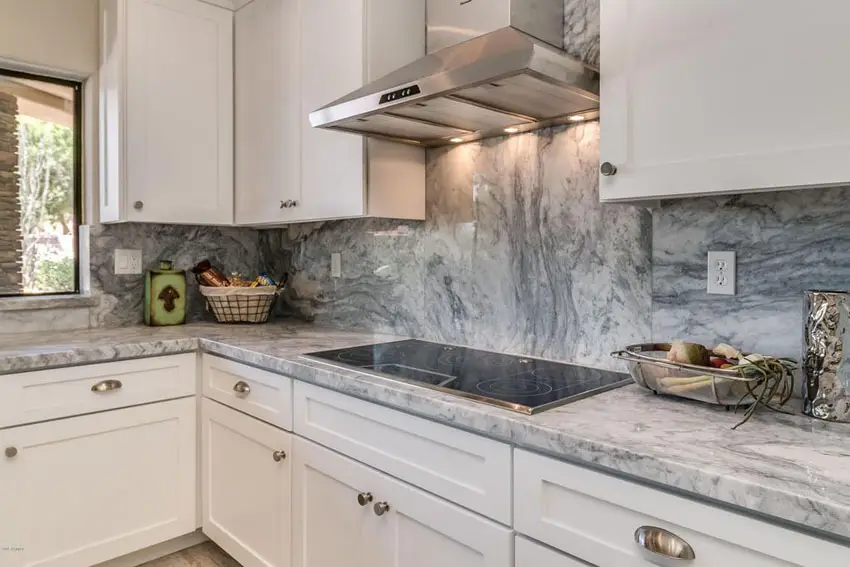 Kitchen with arabescus white marble counter with gray streaks and white cabinets