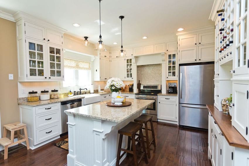 Kitchen with white cabinets, breakfast bar, dark mazama hardwood floors and cafe crema granite counters