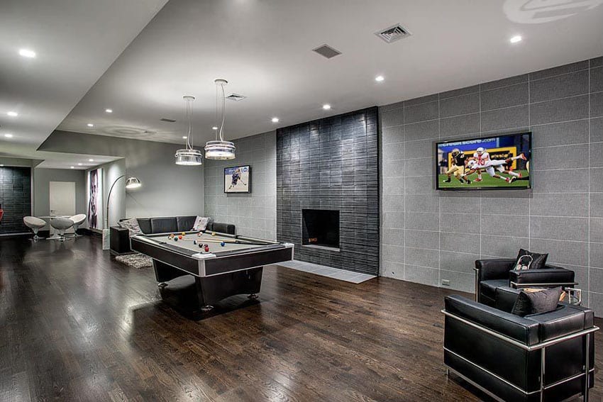 Modern game room with pool table, wood flooring and black tile fireplace