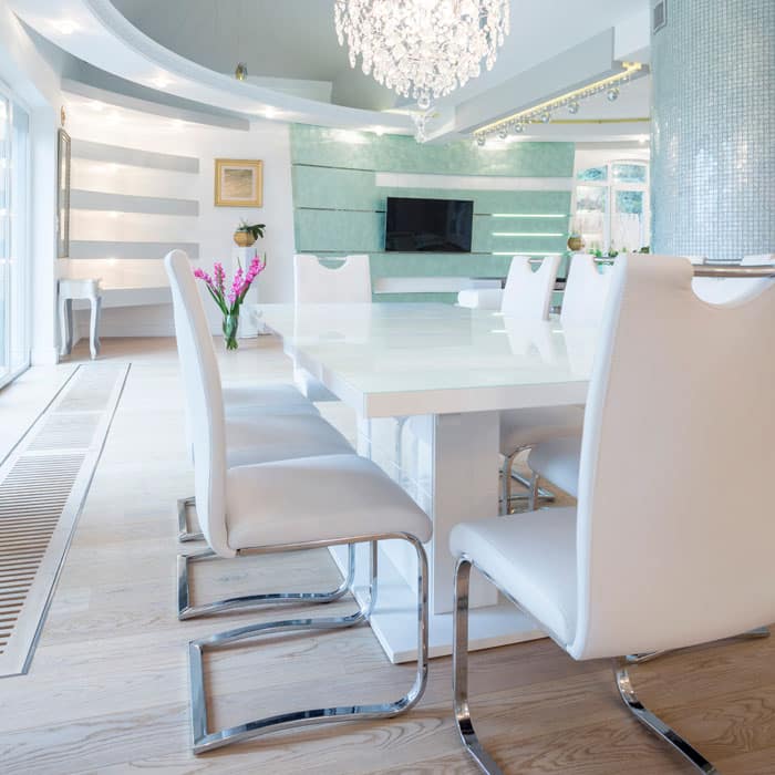 White laminated table with white cantilever chairs and mint green wall as accent