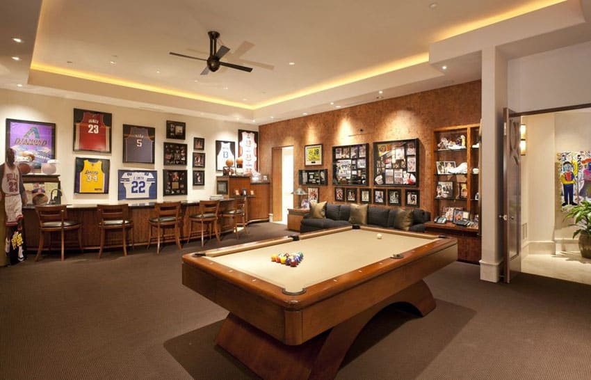Man cave with wood bar, sports jerseys, sports decor and pool table