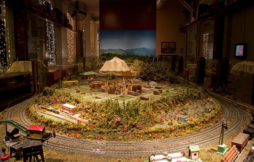 Model train room with forest and town landscape