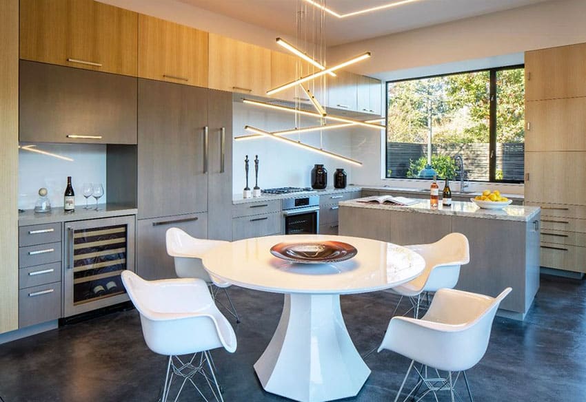 Dining space with all white table and chairs and hanging bar lights