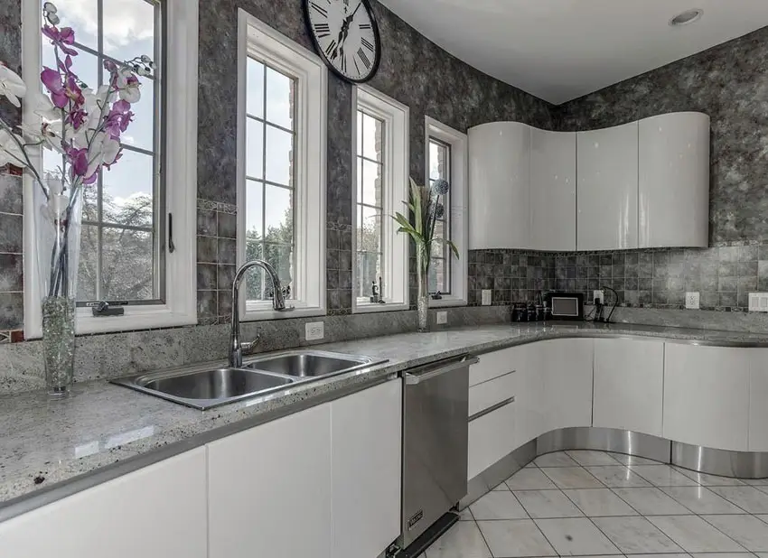 Modern kitchen with andino white granite counters, white cabinets and gray backsplash tile