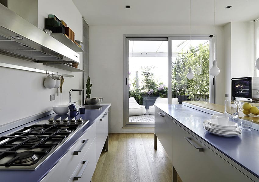 Modern kitchen with blue counters, white cabinets and wood flooring