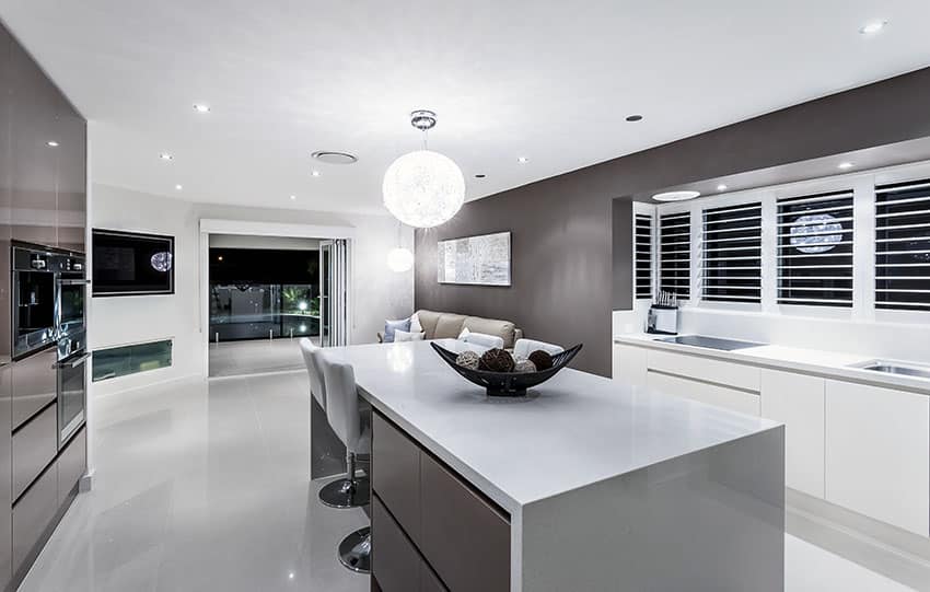 Modern kitchen with dark gray cabinets and white solid surface countertops