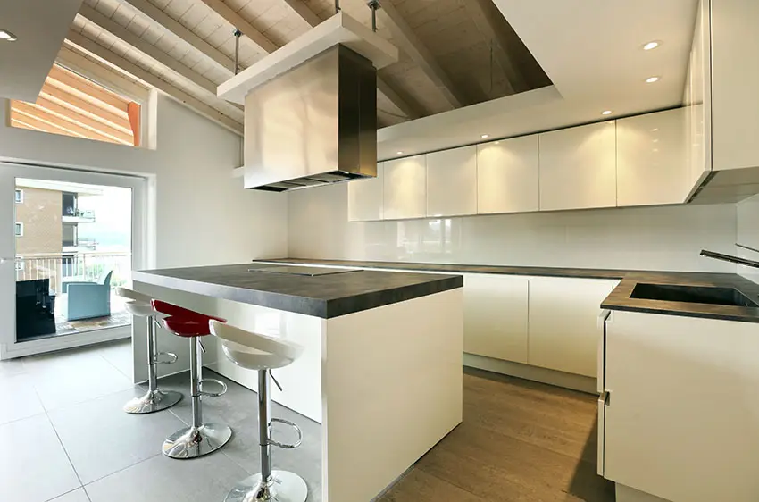Modern kitchen with high gloss white lacquer cabinets and island with black soapstone countertops