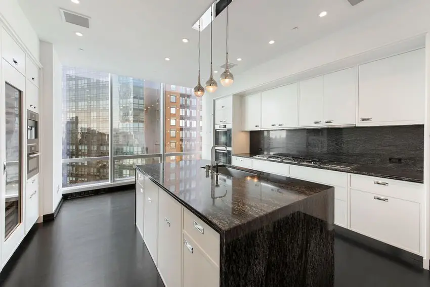 Modern kitchen with white cabinets and apartment city views