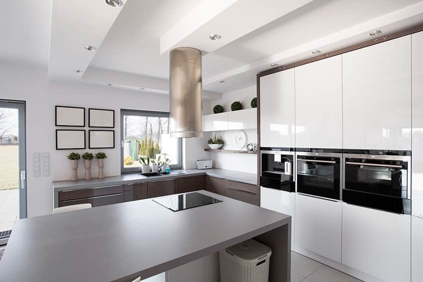 Modern kitchen with white cabinets, black appliances and gray counter island