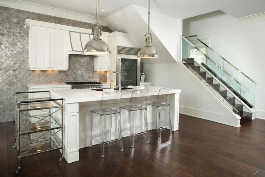 Kitchen with white cabinets, metal backsplash, engineered hardwood floors, and chrome pendant lights