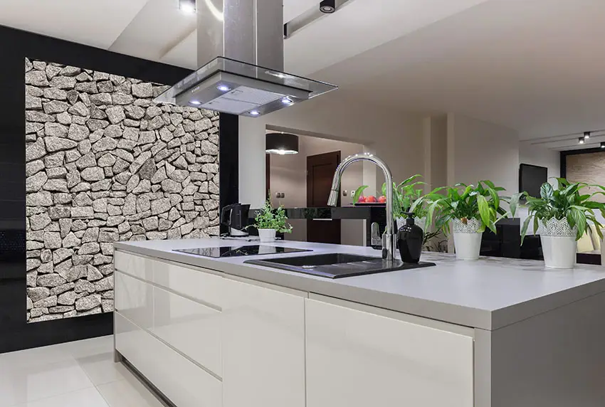 Modern kitchen with white island and stacked stone accent wall