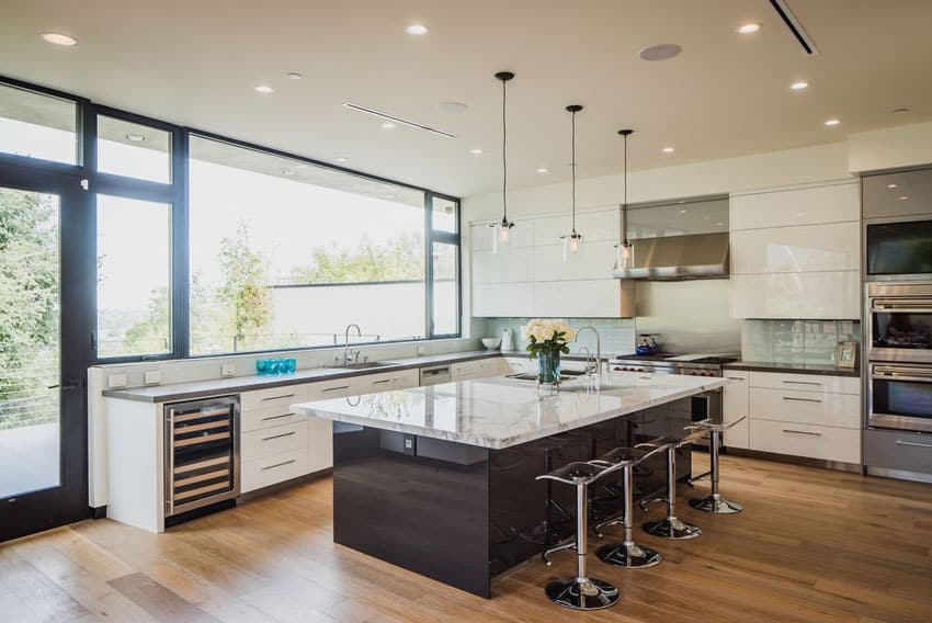 Kitchen with white lacquer cabinets, dark wood island and light wood flooring