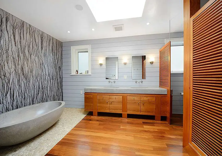 Modern master bathroom with custom travertine bathtub and natural river rock floor