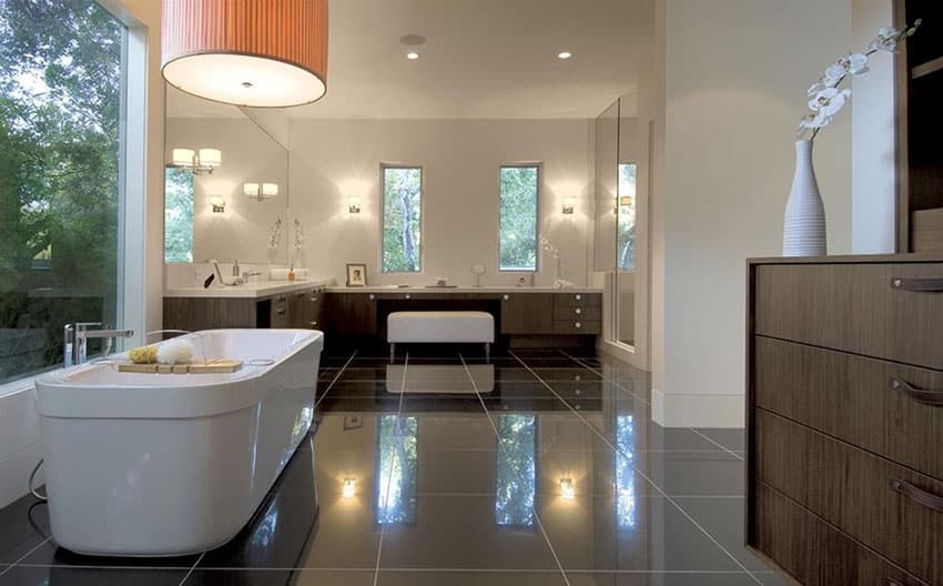 Modern master bathroom with freestanding tub black, granite floors and white vanity counters