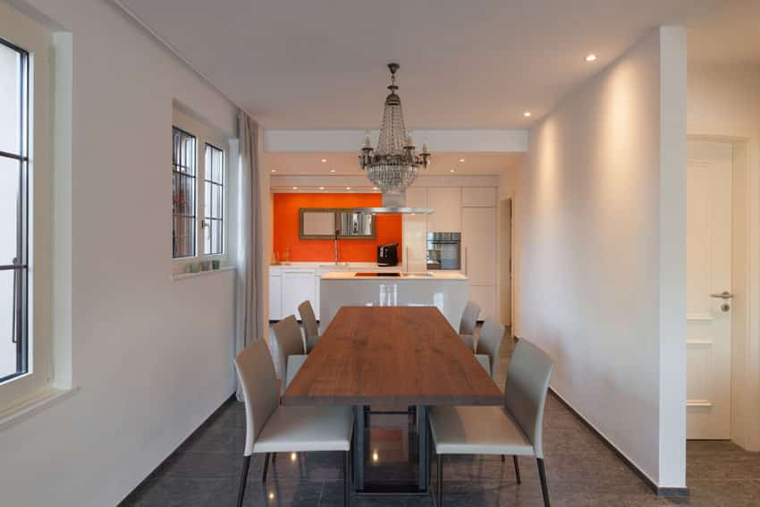 Full size kitchen with orange backsplash, table with solid oak top and classic chandelier