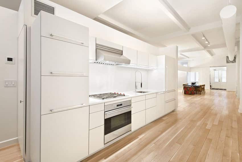 Yellow birch panels as flooring and white storage spaces