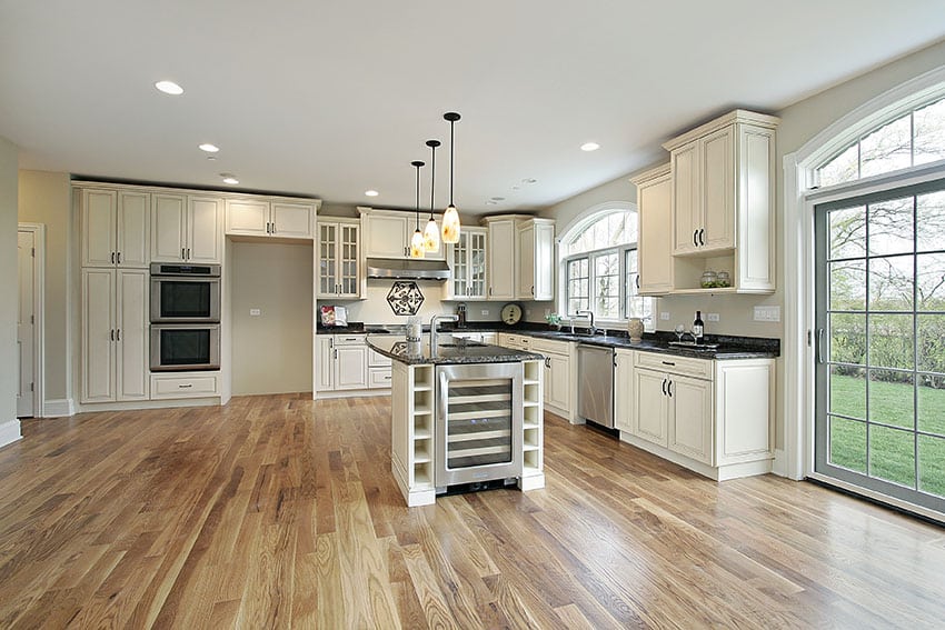 Open plan kitchen with antique cabinets, wood floors and french doors