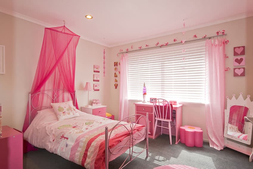 Pink decorated little girls room with bed canopy