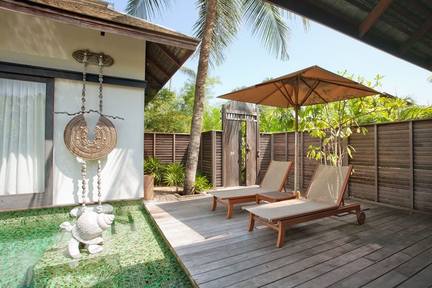 Asian style backyard with horizontal wood fence and lounge deck next to pool