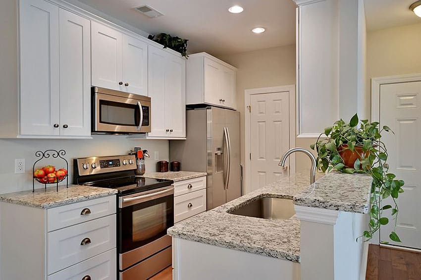 Small galley kitchen in traditional style with white cabinets and peninsula