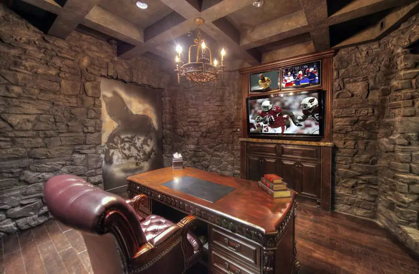 Stone wall office with desk, wood flooring and big screen television