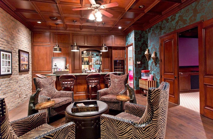 Swanky man cave bar with patterned chairs and door to movie room