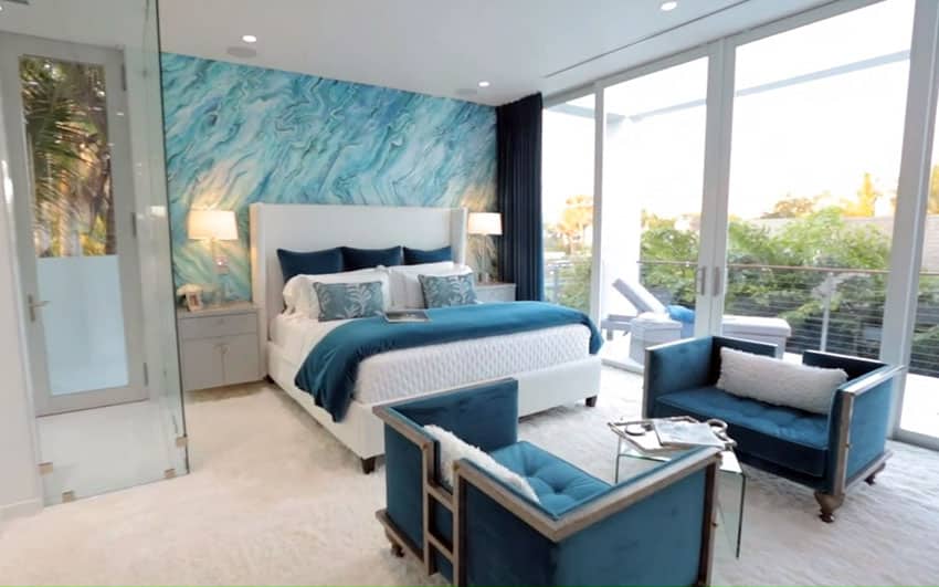 Teal bedroom with accent wall sitting area furniture and balcony