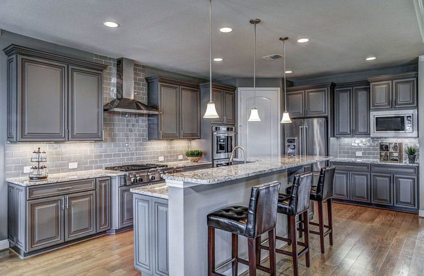 kitchen with l-shaped layout and raised counter island with high backed stools