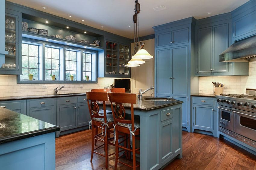 Traditional kitchen with light blue cabinets, white subway tile and dark oak hardwood flooring