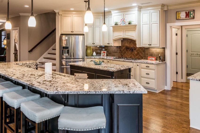 Traditional kitchen with long breakfast bar island, off white cabinets and wood flooring