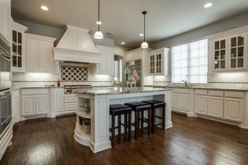 Kitchen with predominantly white theme with diagonal tile backsplash