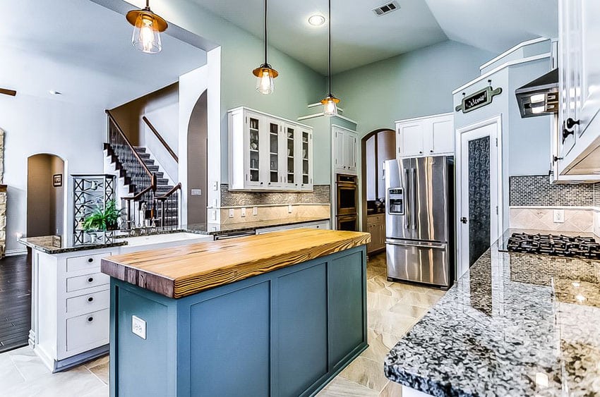 Kitchen with high ceiling and duck egg painted walls with wood counter with blue base