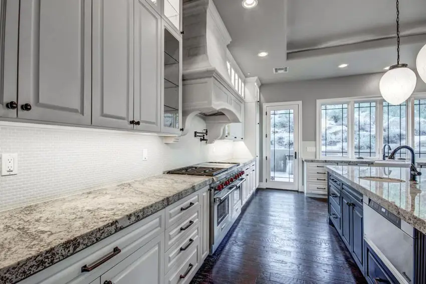 Traditional kitchen with white lower cabinets and gray upper cabinets with blackened hickory floors