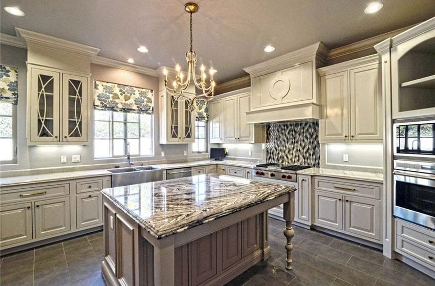 Traditional luxury kitchen with antique white cabinets, chandelier, granite island and mosaic backsplash