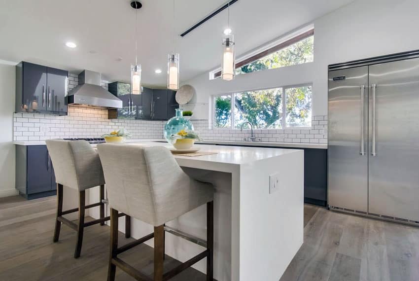 Transitional kitchen with gray cabinets, white counter and subway tile