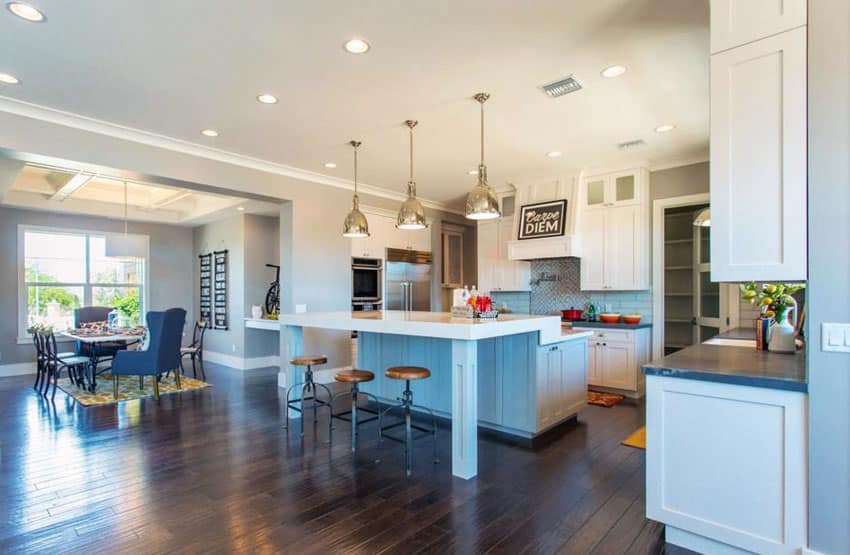 Open space style kitchen with light grey colors with kitchen island with pale blue paint