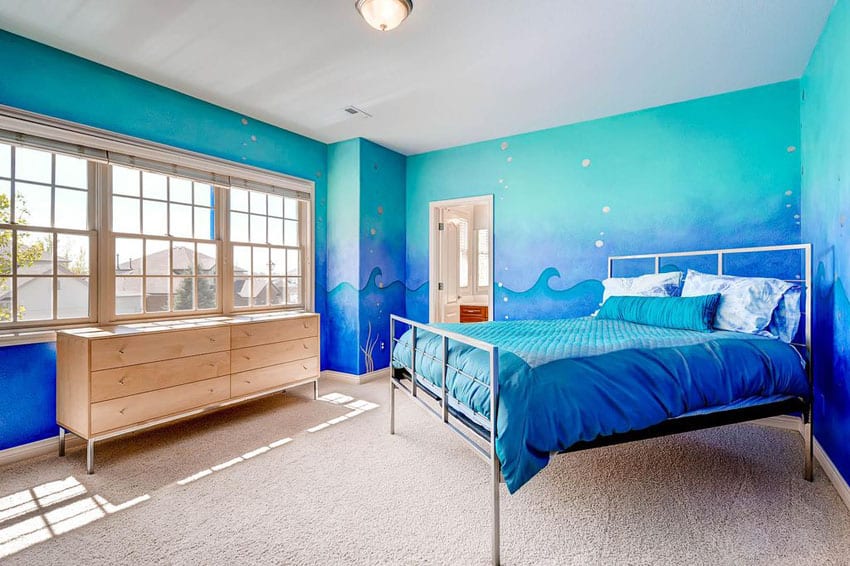 Tropical bedroom with blue painted walls with wave art design