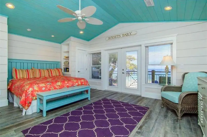 Tropical cottage bedroom with teal color ceiling and teal bed frame