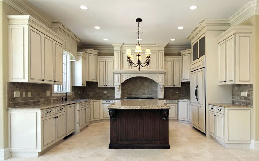 Kitchen with antique white cabinets and dark brown center island with beige granite countertops