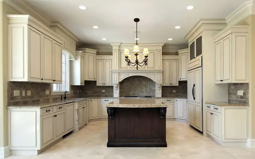 U shaped kitchen with white casework for the walls and dark wood for the island