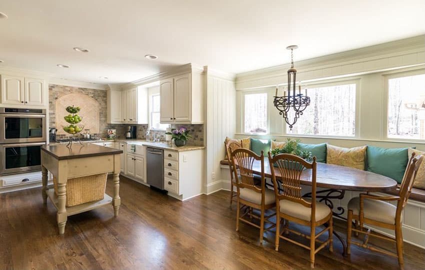 Country style kitchen with slat back chairs, table and white cabinets