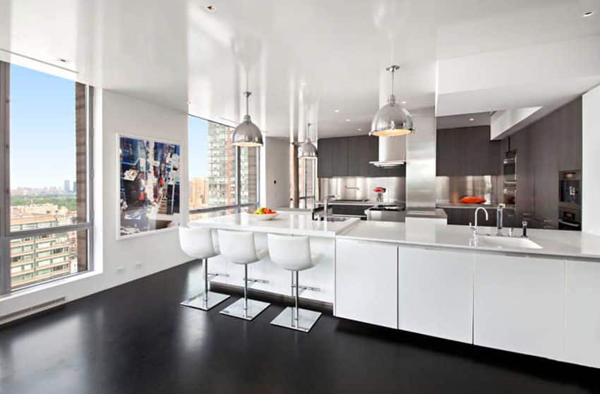 Kitchen with concrete floors and chrome hanging lights and bronze backsplash