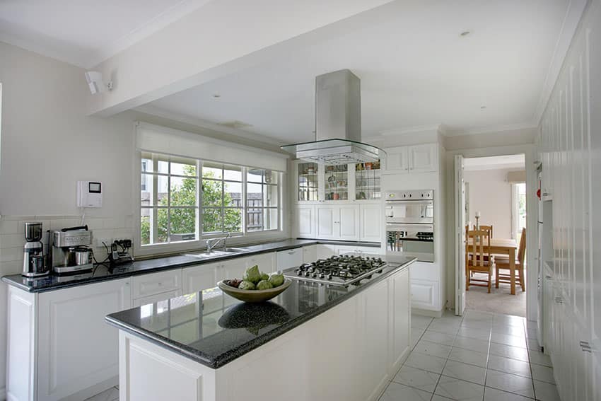 Kitchen with porcelain tile flooring, white ceiling and window panes