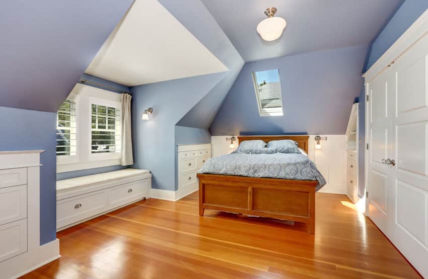 Window seat bench with drawers in bedroom with blue walls